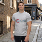 Full-body shot of a model in a classic unisex T-shirt standing outdoors with brick wall background, showcasing fit and style.